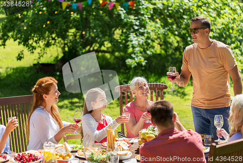 Image of happy family having dinner or summer garden party