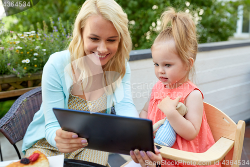 Image of mother and daughter with tablet pc at cafe terrace