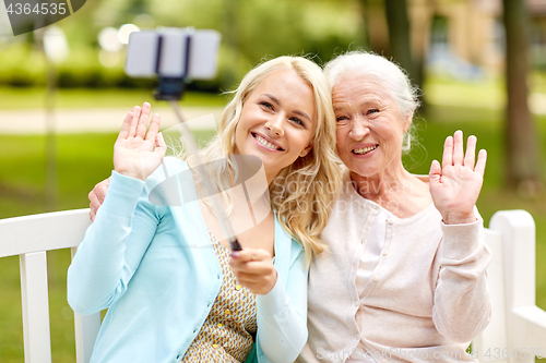 Image of daughter and senior mother taking selfie at park