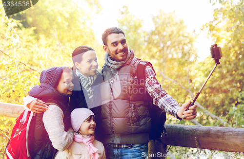 Image of family with backpacks taking selfie and hiking