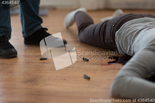 Image of criminal with dead body and bullets at crime scene