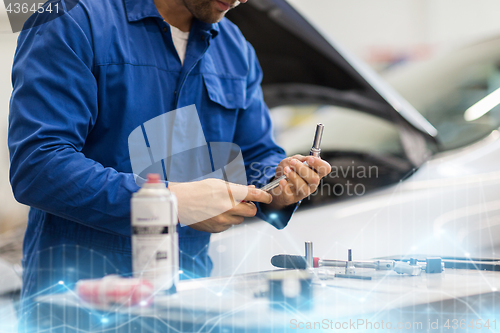 Image of mechanic man with wrench repairing car at workshop