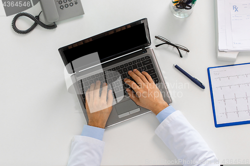 Image of doctor hands typing on laptop at clinic