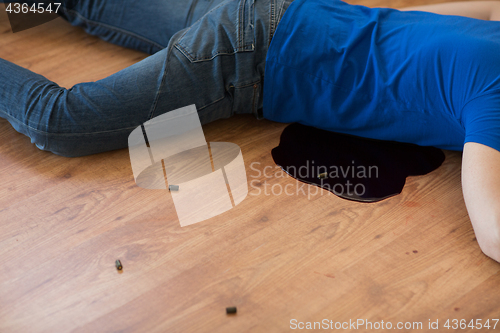 Image of dead man body in blood on floor at crime scene