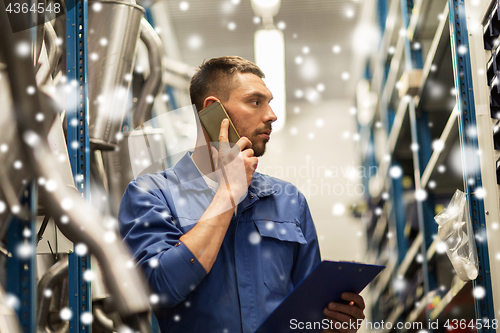 Image of auto mechanic calling on smartphone at car service