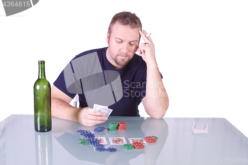 Image of Man with an Empty Whiskey Bottle on a Poker Table