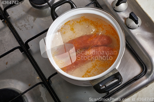 Image of Boiling sausages on stove