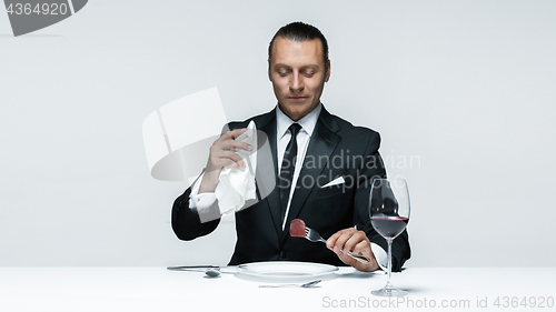 Image of Bloody Halloween theme: crazy man with a knife, fork and meat