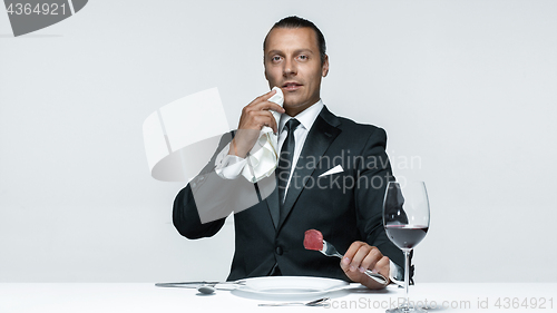 Image of Bloody Halloween theme: crazy man with a knife, fork and meat