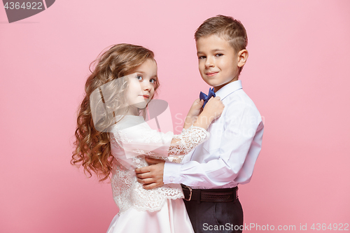Image of Boy and girl standing in studio on pink background