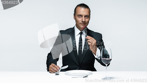 Image of Bloody Halloween theme: crazy man with a knife, fork and meat