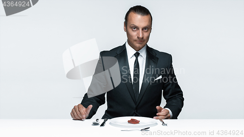 Image of Bloody Halloween theme: crazy man with a knife, fork and meat