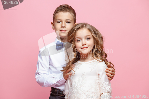 Image of Boy and girl standing in studio on pink background