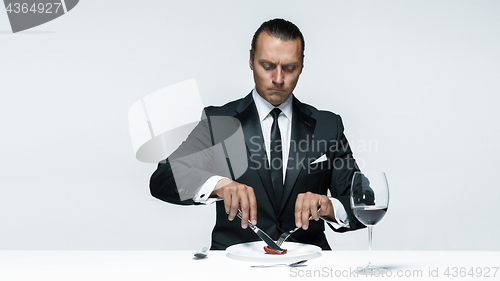 Image of Bloody Halloween theme: crazy man with a knife, fork and meat