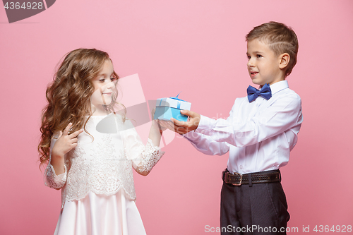 Image of Boy and girl standing in studio on pink background