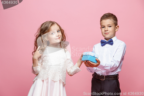 Image of Boy and girl standing in studio on pink background
