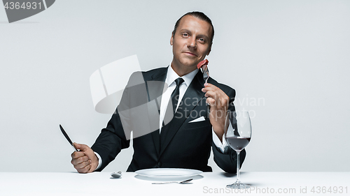 Image of Bloody Halloween theme: crazy man with a knife, fork and meat