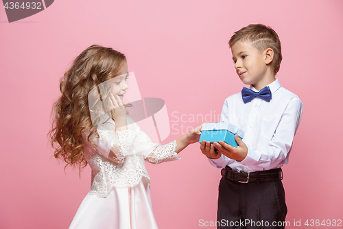 Image of Boy and girl standing in studio on pink background