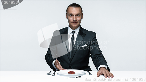 Image of Bloody Halloween theme: crazy man with a knife, fork and meat