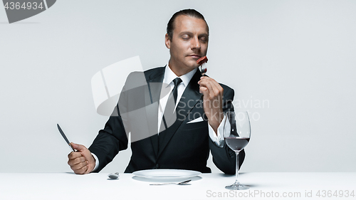 Image of Bloody Halloween theme: crazy man with a knife, fork and meat