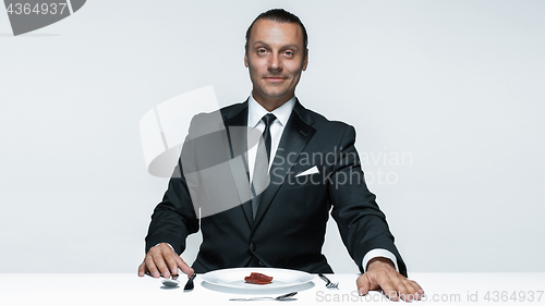 Image of Bloody Halloween theme: crazy man with a knife, fork and meat