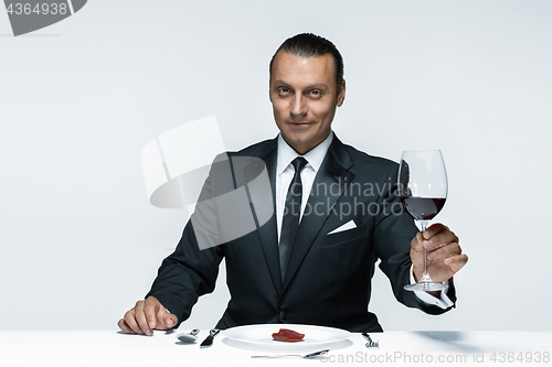 Image of Bloody Halloween theme: crazy man with a knife, fork and meat