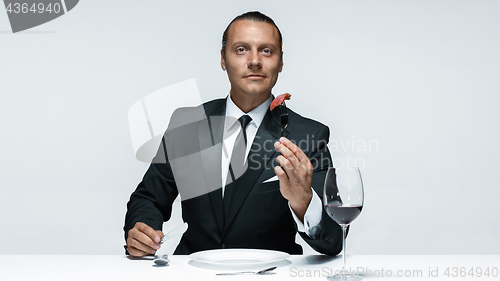 Image of Bloody Halloween theme: crazy man with a knife, fork and meat