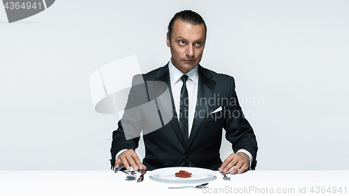 Image of Bloody Halloween theme: crazy man with a knife, fork and meat