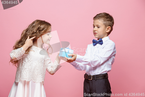 Image of Boy and girl standing in studio on pink background