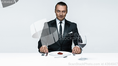 Image of Bloody Halloween theme: crazy man with a knife, fork and meat