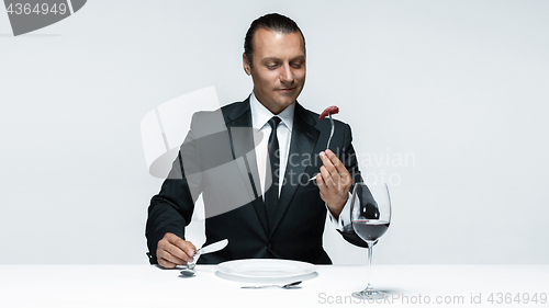 Image of Bloody Halloween theme: crazy man with a knife, fork and meat