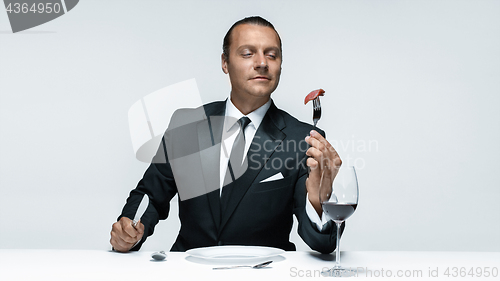 Image of Bloody Halloween theme: crazy man with a knife, fork and meat