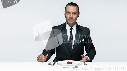 Image of Bloody Halloween theme: crazy man with a knife, fork and meat