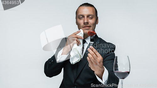 Image of Bloody Halloween theme: crazy man with a knife, fork and meat