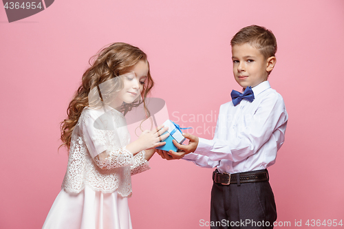 Image of Boy and girl standing in studio on pink background