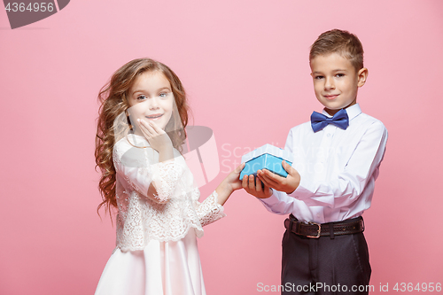 Image of Boy and girl standing in studio on pink background