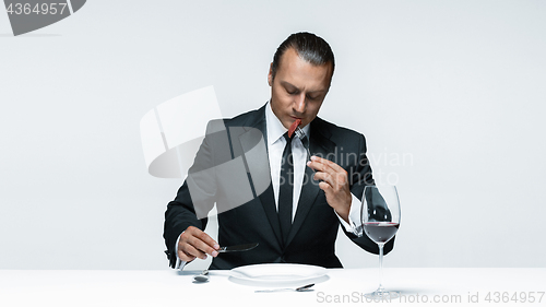 Image of Bloody Halloween theme: crazy man with a knife, fork and meat