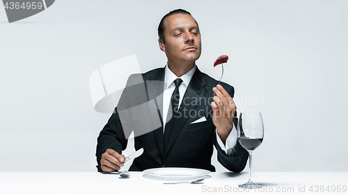 Image of Bloody Halloween theme: crazy man with a knife, fork and meat