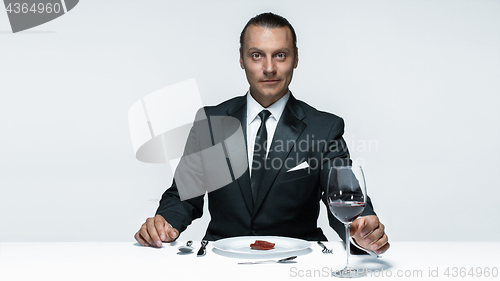 Image of Bloody Halloween theme: crazy man with a knife, fork and meat