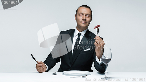 Image of Bloody Halloween theme: crazy man with a knife, fork and meat