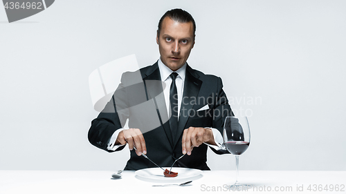 Image of Bloody Halloween theme: crazy man with a knife, fork and meat