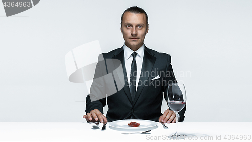 Image of Bloody Halloween theme: crazy man with a knife, fork and meat