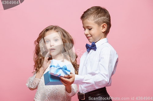 Image of Boy and girl standing in studio on pink background