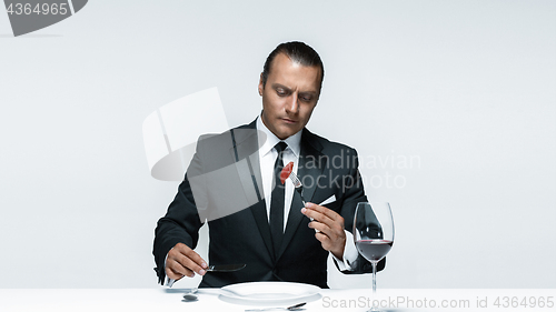 Image of Bloody Halloween theme: crazy man with a knife, fork and meat