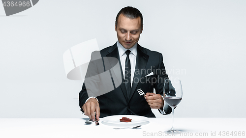 Image of Bloody Halloween theme: crazy man with a knife, fork and meat