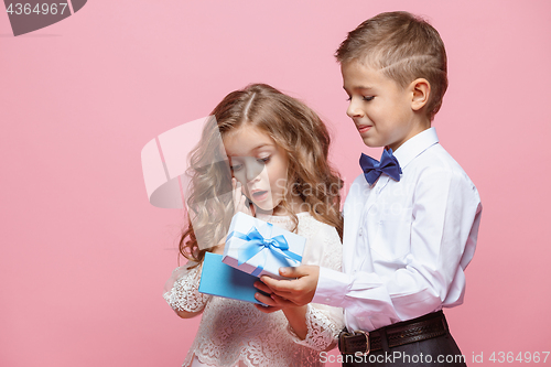 Image of Boy and girl standing in studio on pink background