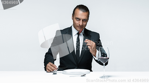 Image of Bloody Halloween theme: crazy man with a knife, fork and meat