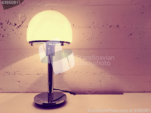 Image of Lamp with round lampshade near concrete wall