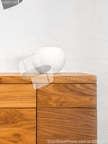 Image of Simple ceramic vase decorating a chest of drawers
