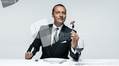 Image of Bloody Halloween theme: crazy man with a knife, fork and meat